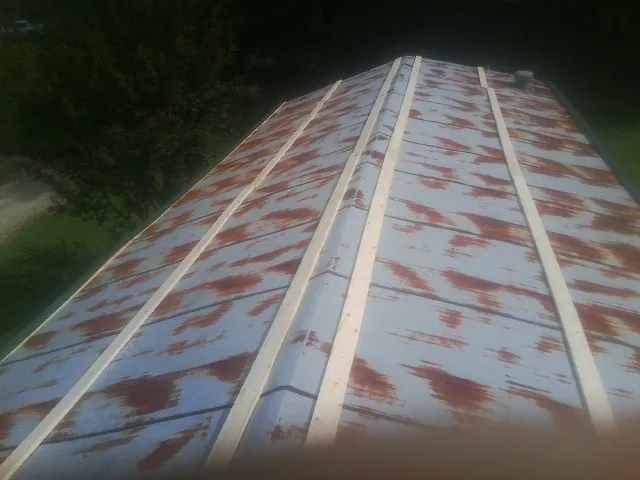 Rusted metal roof panels with new wood purlins before replacement — Storm Damage Roof Repair in Roswell by Roofing Brothers